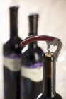 Closeup view of bottle of red wine with corkscrew — Stock Photo