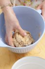 Primo piano vista della mano impastare pasta biscotto in una ciotola — Foto stock