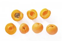 Свежие абрикосы с половинками — стоковое фото
