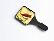 Raclette with chorizo on server — Stock Photo