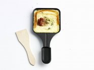 Raclette con tocino en sartén - foto de stock