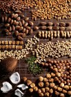 Вид сверху на разнообразные орехи, расположенные на коричневом коврике рафии — стоковое фото