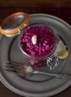 An Open Jar of Pickled Cabbage on black plate with fork — Stock Photo