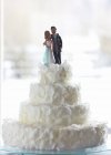 Hochzeitstorte mit Brautpaar geschmückt — Stockfoto