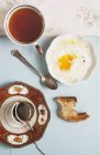 Вид на горячий чай с жареным яйцом и тостами — стоковое фото