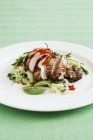 Крупный план маринованной куриной грудки и салата на белой тарелке — стоковое фото