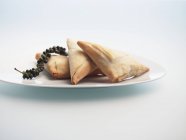 Primo piano vista di Briouats riempito pacchi pasticceria su piatto bianco — Foto stock