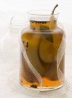 Closeup view of preserved pears in carafe with ribbon — Stock Photo