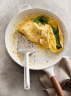 A spinach omelette in the frying pan with server — Stock Photo