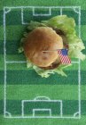 Vista superior de hambúrguer com uma bandeira dos EUA em um tapete de campo de futebol — Fotografia de Stock