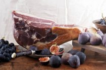 Leg of Parma ham with figs — Stock Photo