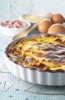 Closeup view of bacon Quiche in the dish on a cooling rack — Stock Photo