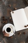 Nahaufnahme von Espresso mit Keksen, Zapfen und geöffnetem Notizbuch — Stockfoto