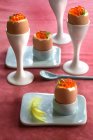 Vista de cerca de huevos cocidos con caviar en copas de huevo - foto de stock