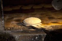 Unbaked bread on peel — Stock Photo
