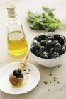 Schwarze Oliven mit Kräutern in Schüssel — Stockfoto