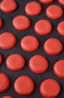 Mitades de macarrones rojos recién horneados - foto de stock