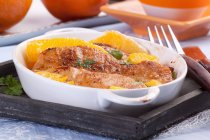 Closeup view of chicken breast with oranges in a baking dish — Stock Photo