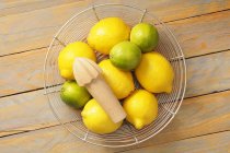 Lemons and limes in wire basket — Stock Photo
