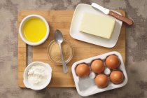 Top view of assorted baking ingredients including eggs, sugar, butter, flour and oil — Stock Photo