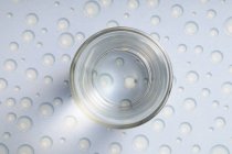 Vaso de agua en la mesa con patrón de perlas - foto de stock