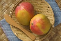 Fresh mangos in basket — Stock Photo