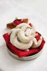 Closeup view of hazelnut crescent pastries with icing on red cloth — Stock Photo