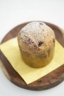 Closeup view of Panettone with icing sugar on tissue and round wooden board — Stock Photo
