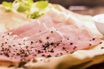 Sliced ham with black pepper — Stock Photo