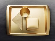 Вид сверху на золотой одноразовый поднос, чашку, салфетку и картонную коробку — стоковое фото