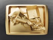 Vue de dessus des restes d'un repas de restauration rapide sur un plateau de couleur or — Photo de stock