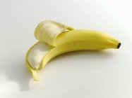 Banana parcialmente descascada — Fotografia de Stock