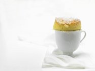 Closeup view of vanilla souffle with icing sugar in white cup — Stock Photo
