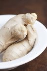 Fresh ginger roots in plate — Stock Photo