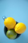 Zitronen und Limetten in Tasse — Stockfoto