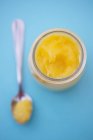 Vista superior closeup de coalhada de limão em um jarro e em uma colher — Fotografia de Stock