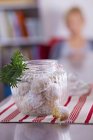 Closeup view of butter biscuits in storage jar with sprig of fir — Stock Photo