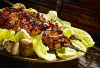 Closeup view of grilled teriyaki chicken on Caesar salad — Stock Photo