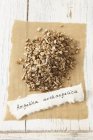 Elevated view of dried garden angelica heap on paper with label — Stock Photo