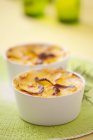 Potato gratin in ramekins in white pots on blurred background — Stock Photo
