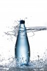 Вид крупным планом бутылки с водой, попавшей под струю воды — стоковое фото