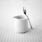 Jug of milk with a teaspoon — Stock Photo