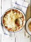 Top view of rhubarb crumble with spoon in enamel dish — Stock Photo