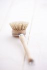 Closeup view of a wooden washing-up brush on wooden planks — Stock Photo