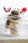 Closeup view of poppyseed tartlets with pistachios in glass and cellophane wrap — Stock Photo