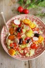 Insalata di quinoa con ravanelli e pomodorini sul piatto con cucchiaio di legno sulla superficie di legno — Foto stock