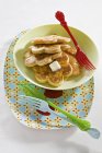 Sweetcorn pancakes on plastic plates — Stock Photo