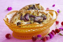 Closeup view of Focaccia with red onions in paper lined bowl — Stock Photo