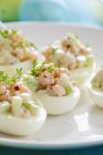 Ovos recheados com pepino, camarão e agrião na placa branca — Fotografia de Stock