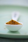Curry in polvere in cucchiaio di porcellana — Foto stock